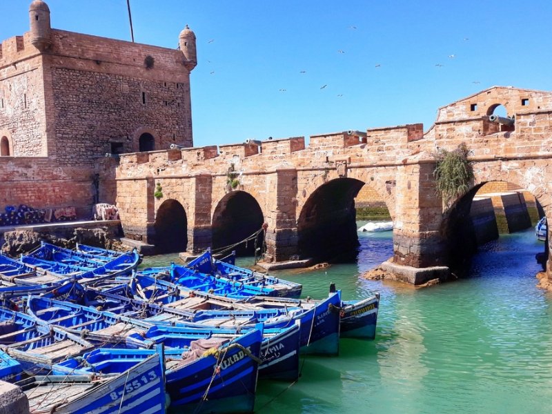 Traditional bright blue wooden fishing boats docked at the historic coastal port of Essaouira