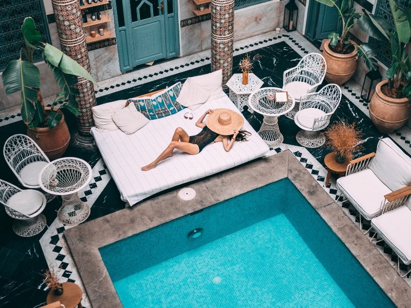 Stunning inner courtyard of a high-end luxury Moroccan riad featuring a central pool and grand architectural arches